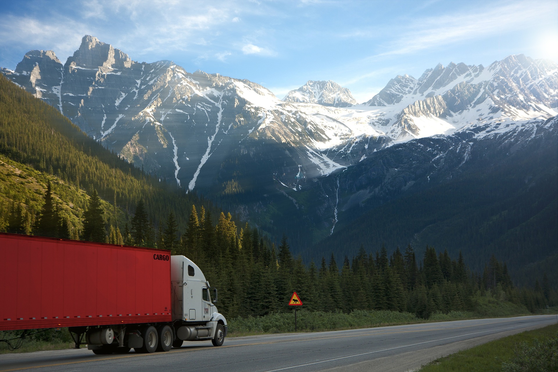 logistica sostenibile - camion su strada con sfondo di montagne e alberi