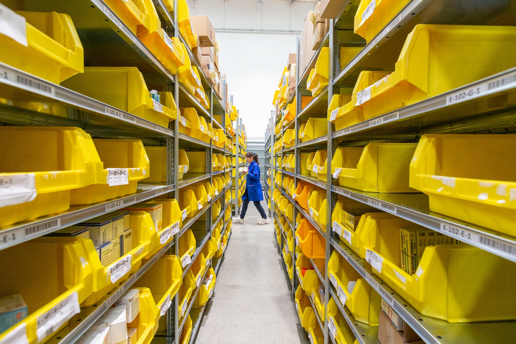 Étagères de produits dans un entrepôt et personne qui fait le picking
